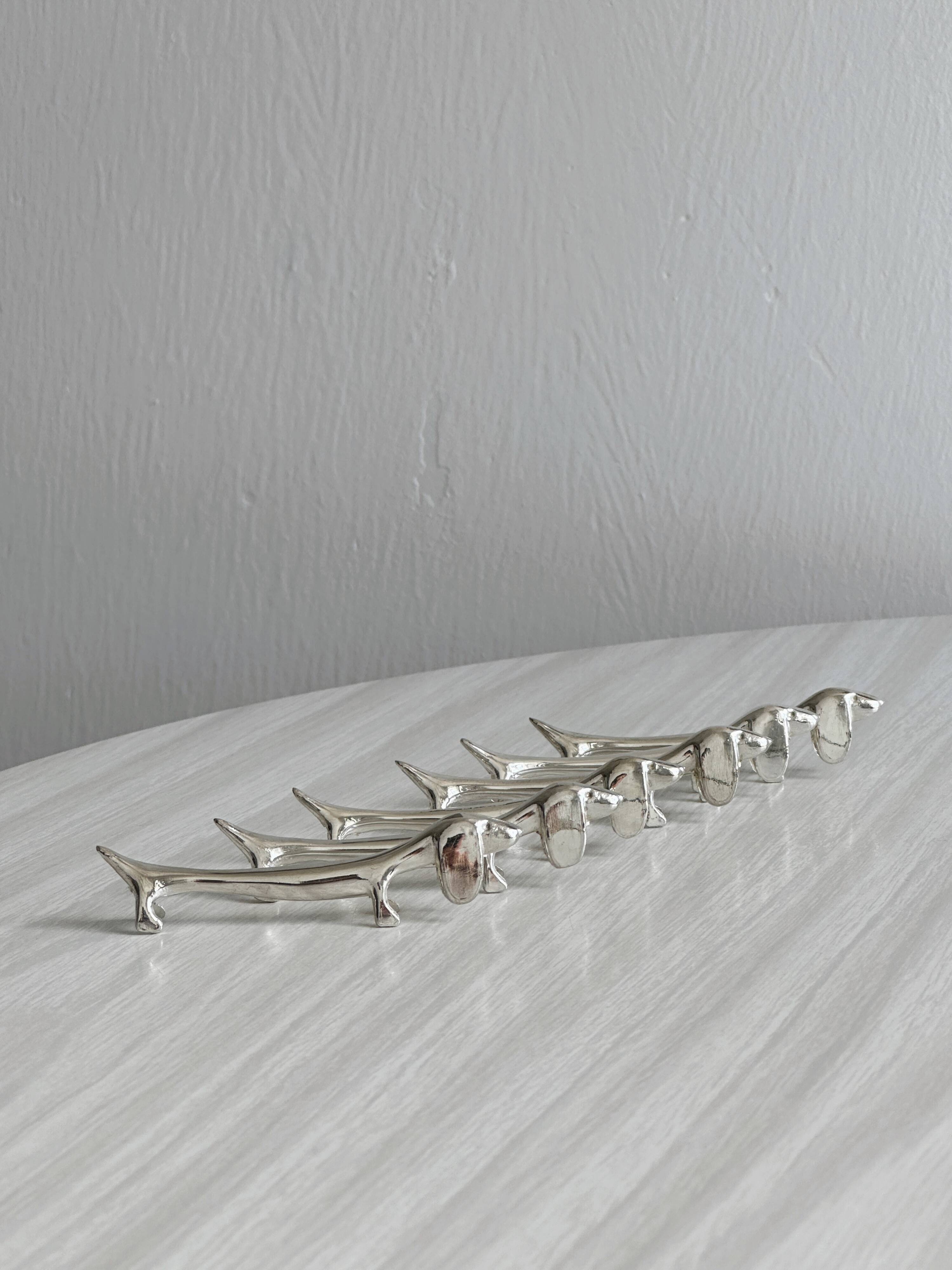 6 dog-shaped knife rests, in silver-plated metal.