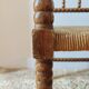 Antique corner chair by the fire with turned wood and straw seat.