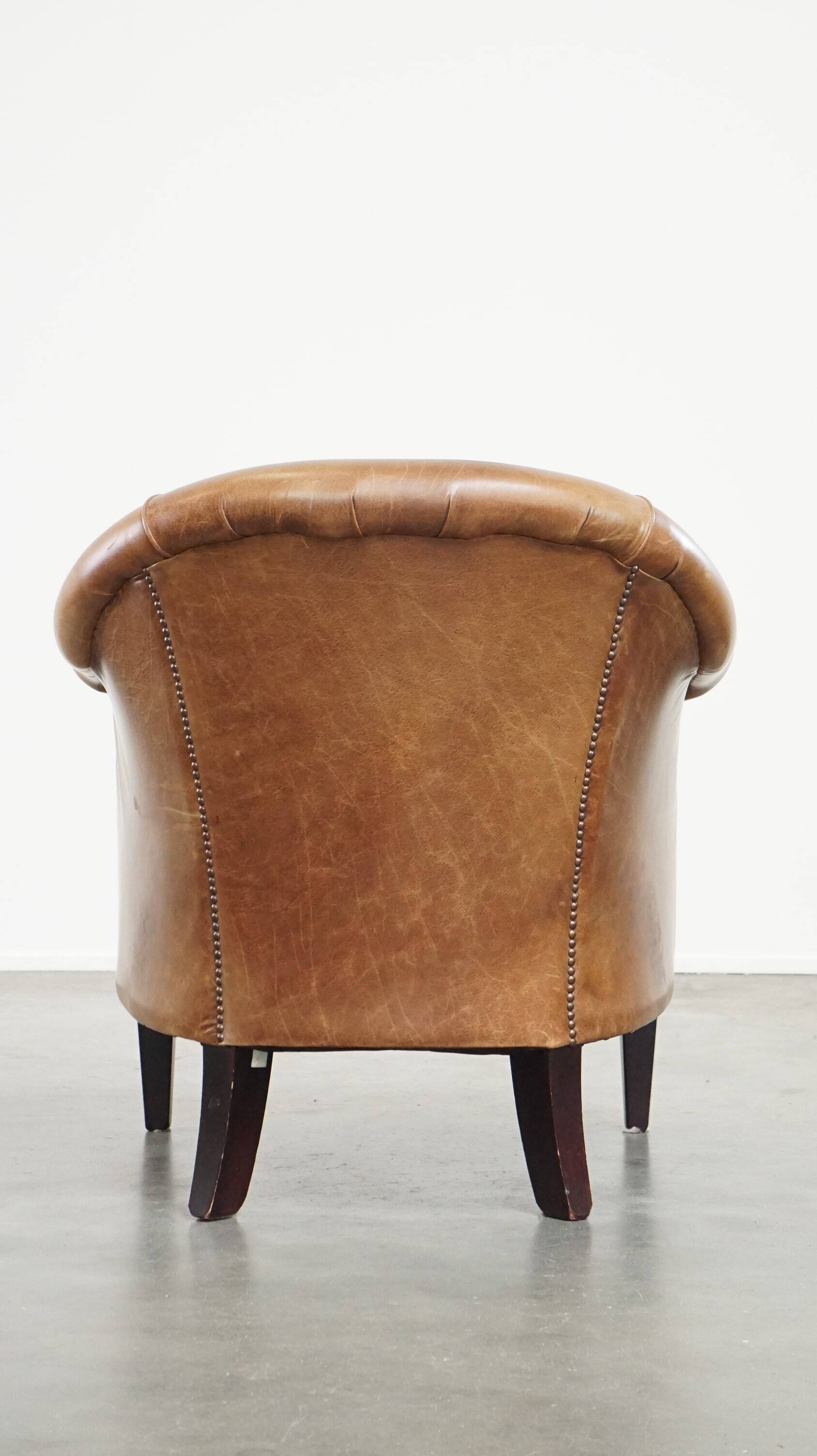 Very comfortable, elegant leather club armchair with a removable seat cushion and timeless design