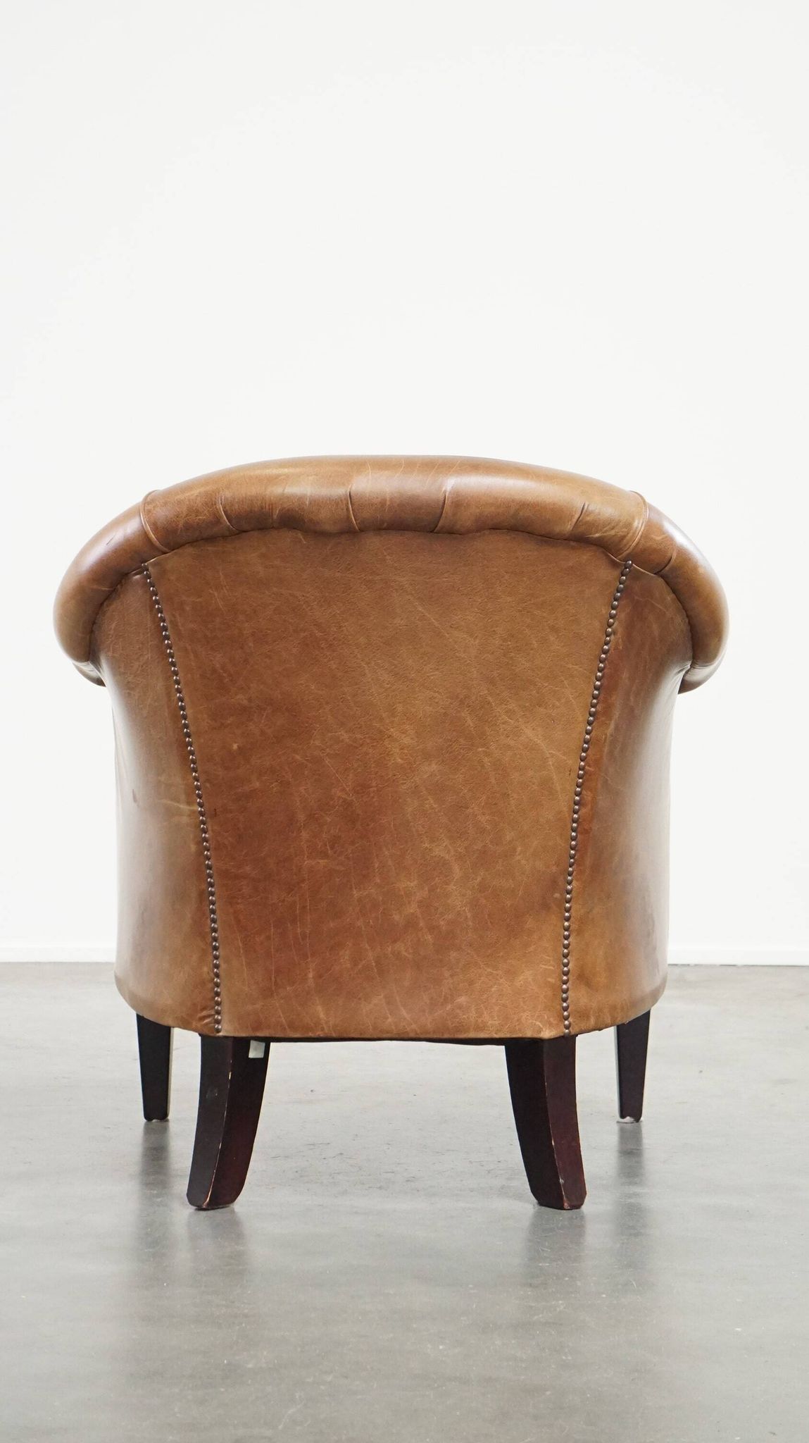 Very comfortable, elegant leather club armchair with a removable seat cushion and timeless design