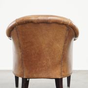 Very comfortable, elegant leather club armchair with a removable seat cushion and timeless design