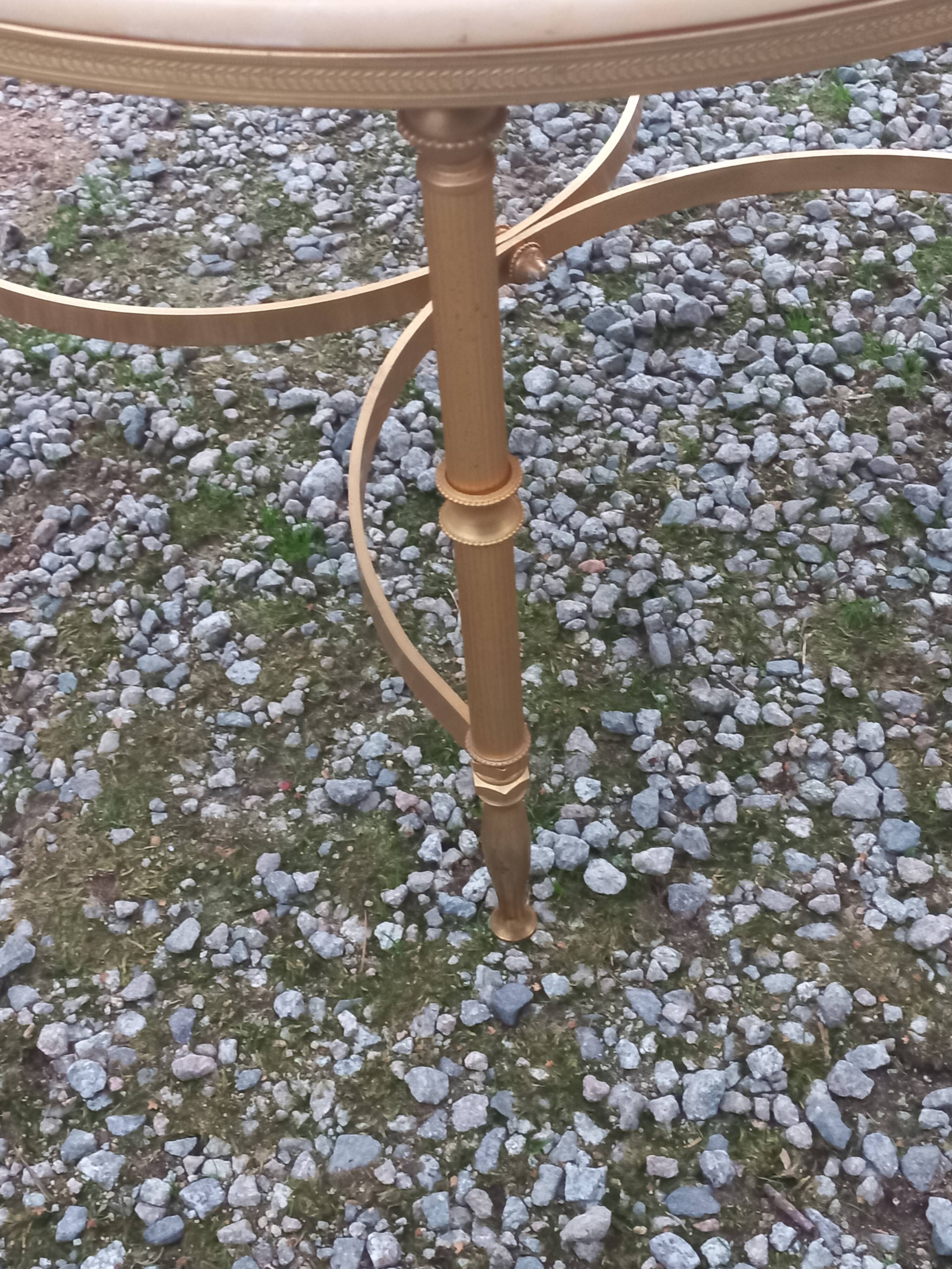 Round neoclassical coffee table with a marble top and golden metal base.