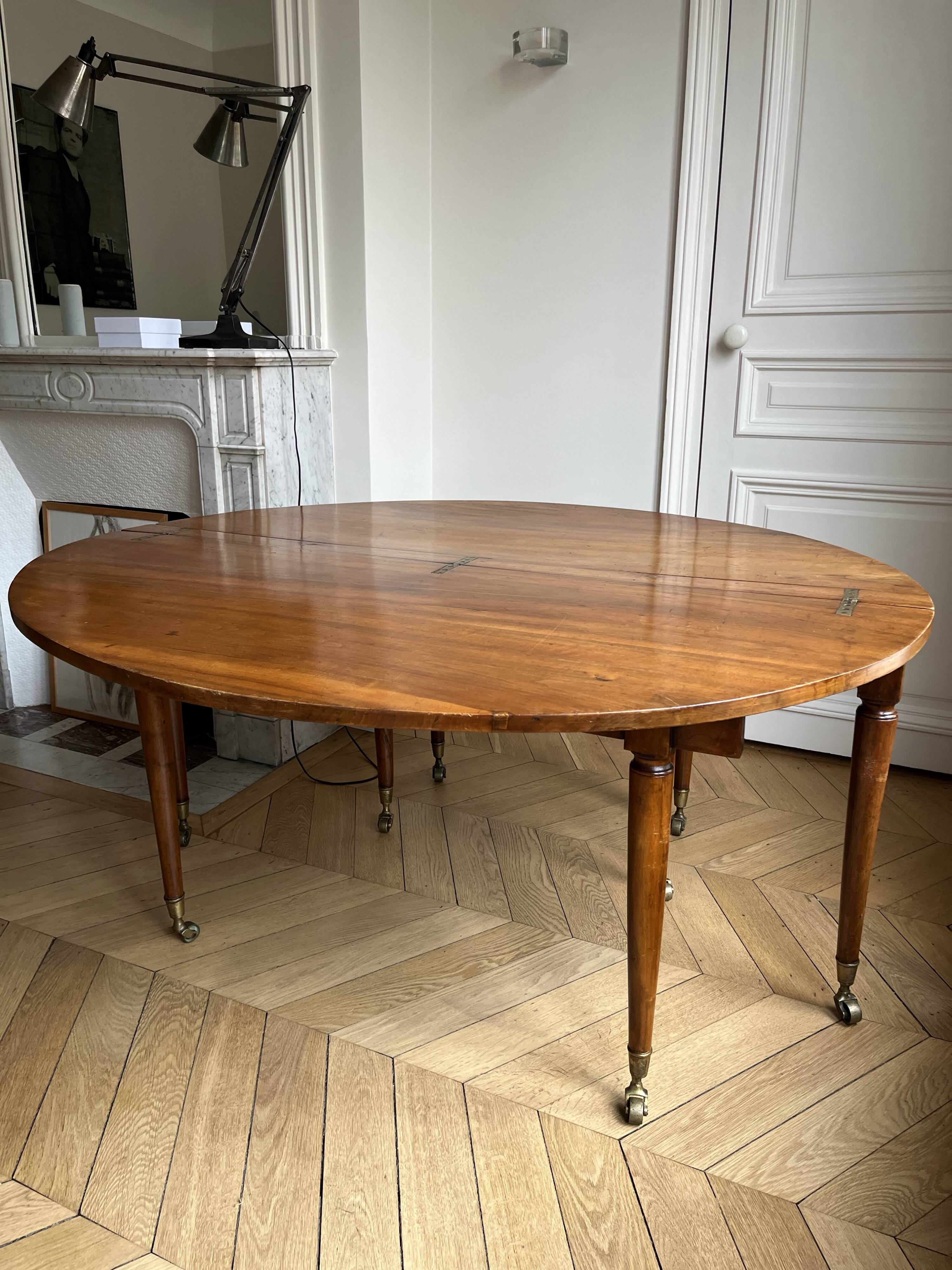 Large oval table from the early 19th century in walnut, 3.17m with extensions.