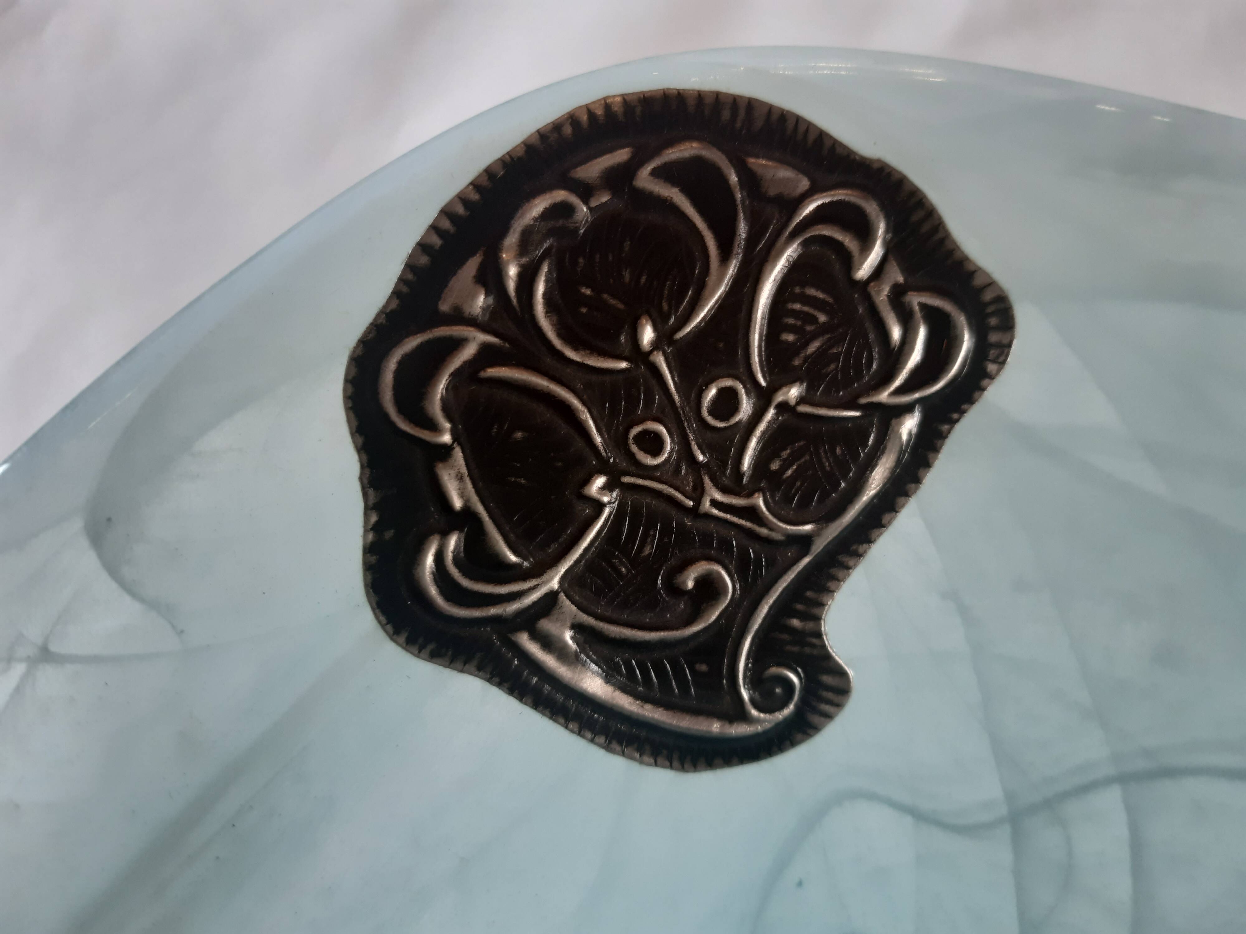 Handcrafted glass fruit bowl with ribbed design set with pewter medallions.