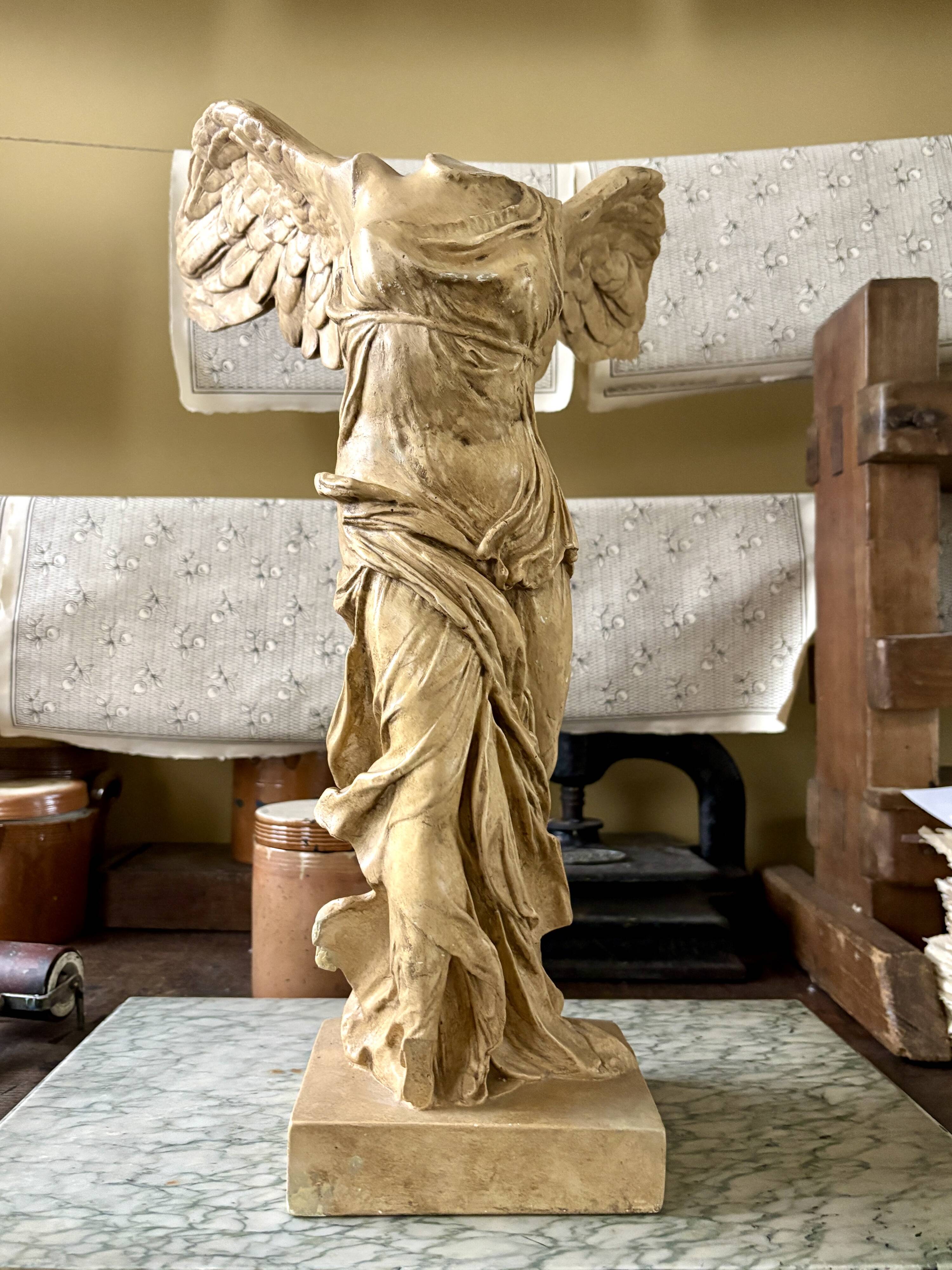 "Winged Victory of Samothrace", beige plaster statuette