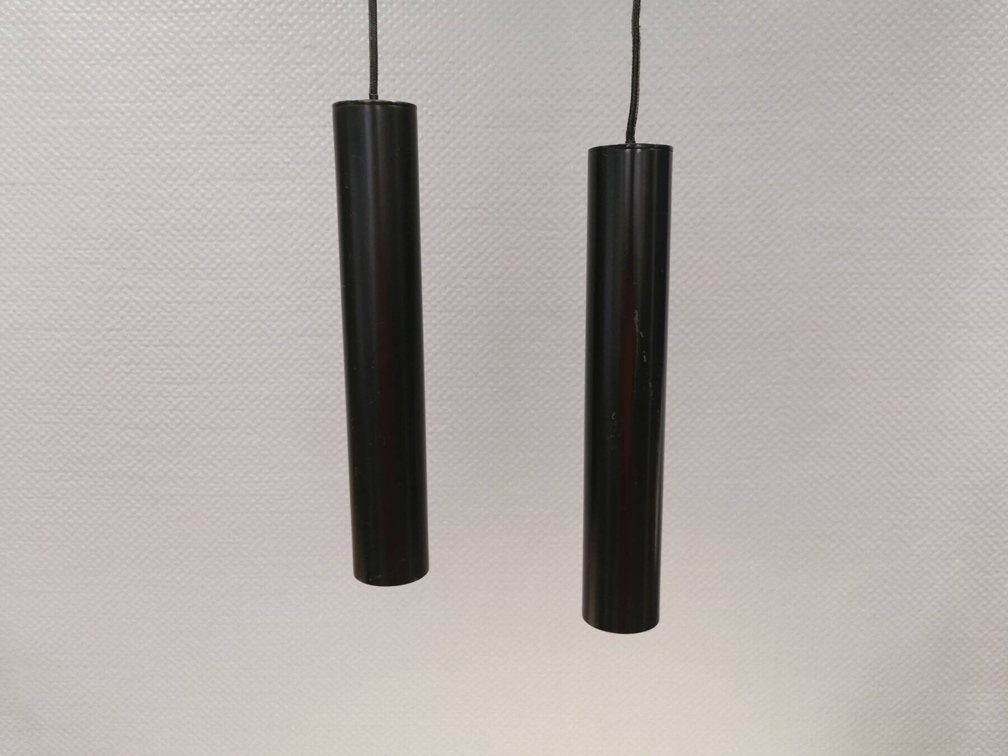 Two cylinder-shaped hanging lamps in black lacquer
