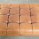 Sheepskin ottoman/coffee table on wheels in English chesterfield style
