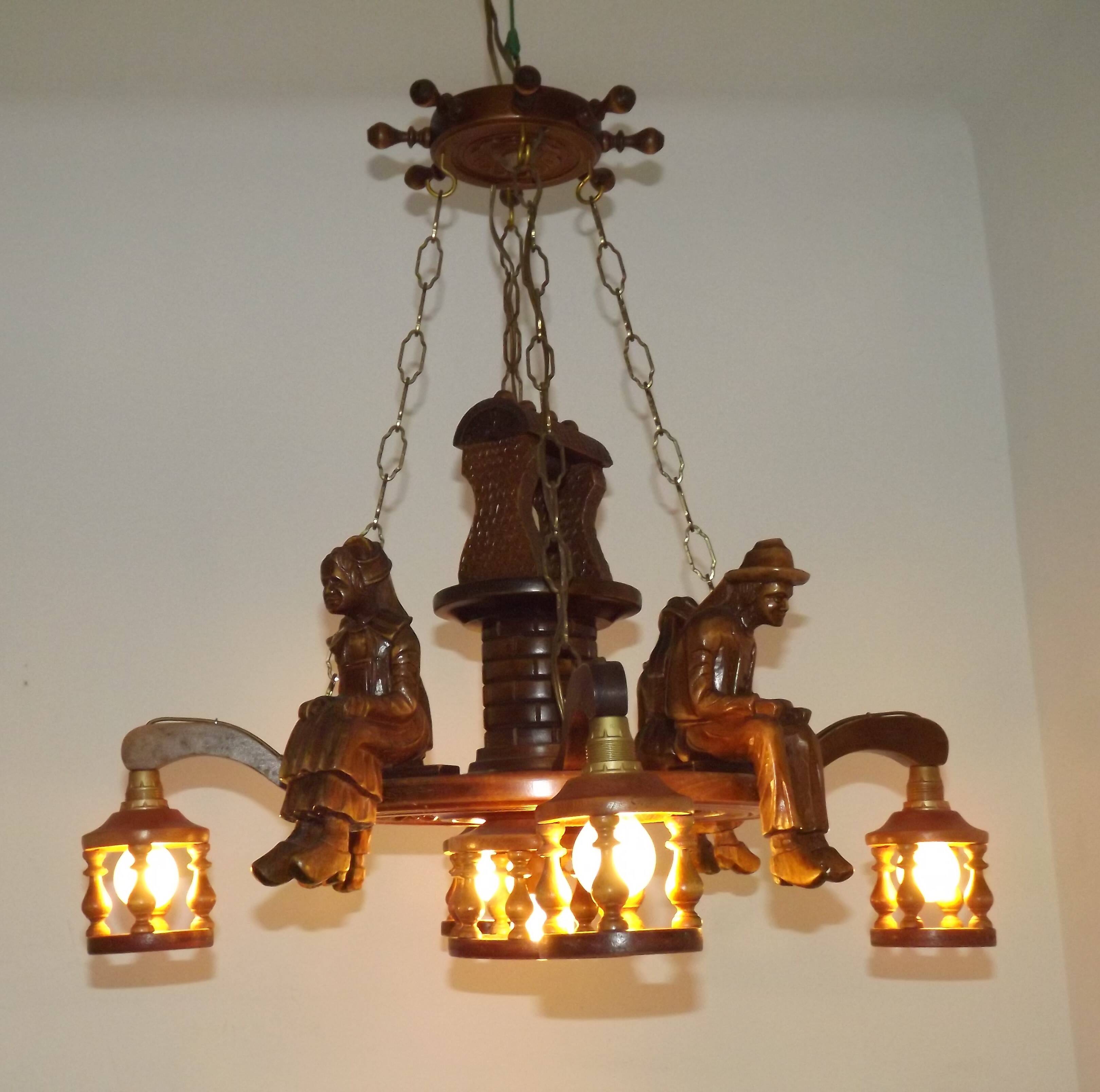 French vintage Breton chandelier with hand-carved figures, well, and lantern lights.