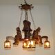French vintage Breton chandelier with hand-carved figures, well, and lantern lights.