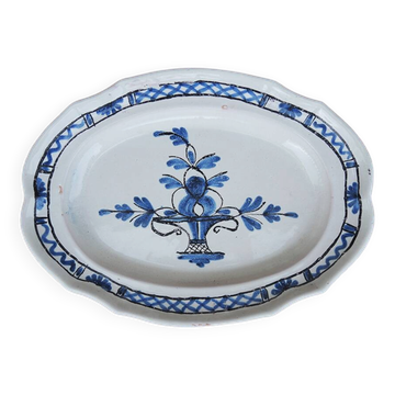 Old large oval ceramic dish with a black bottom.