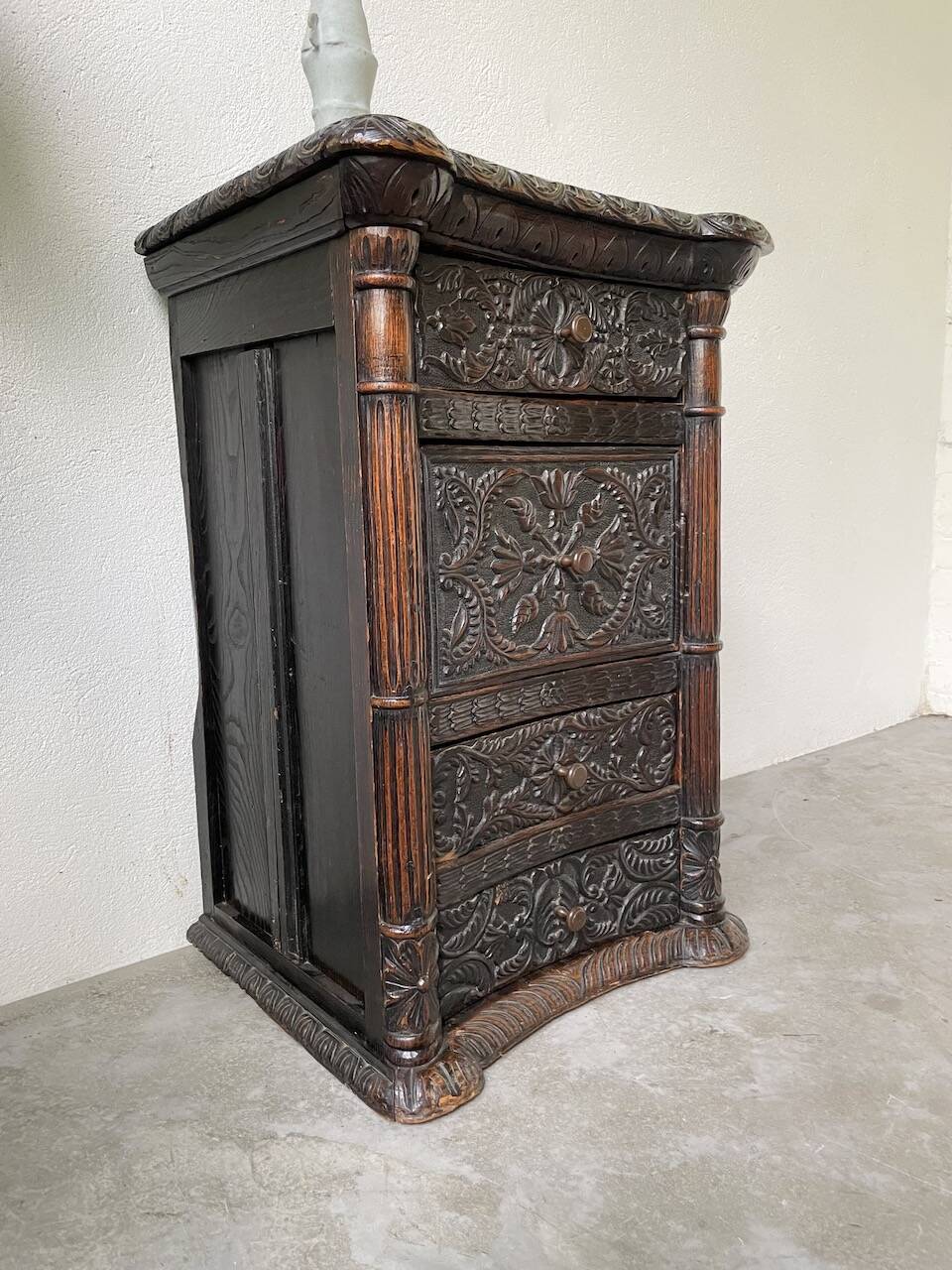 19th century chest of drawers in carved blackened pine