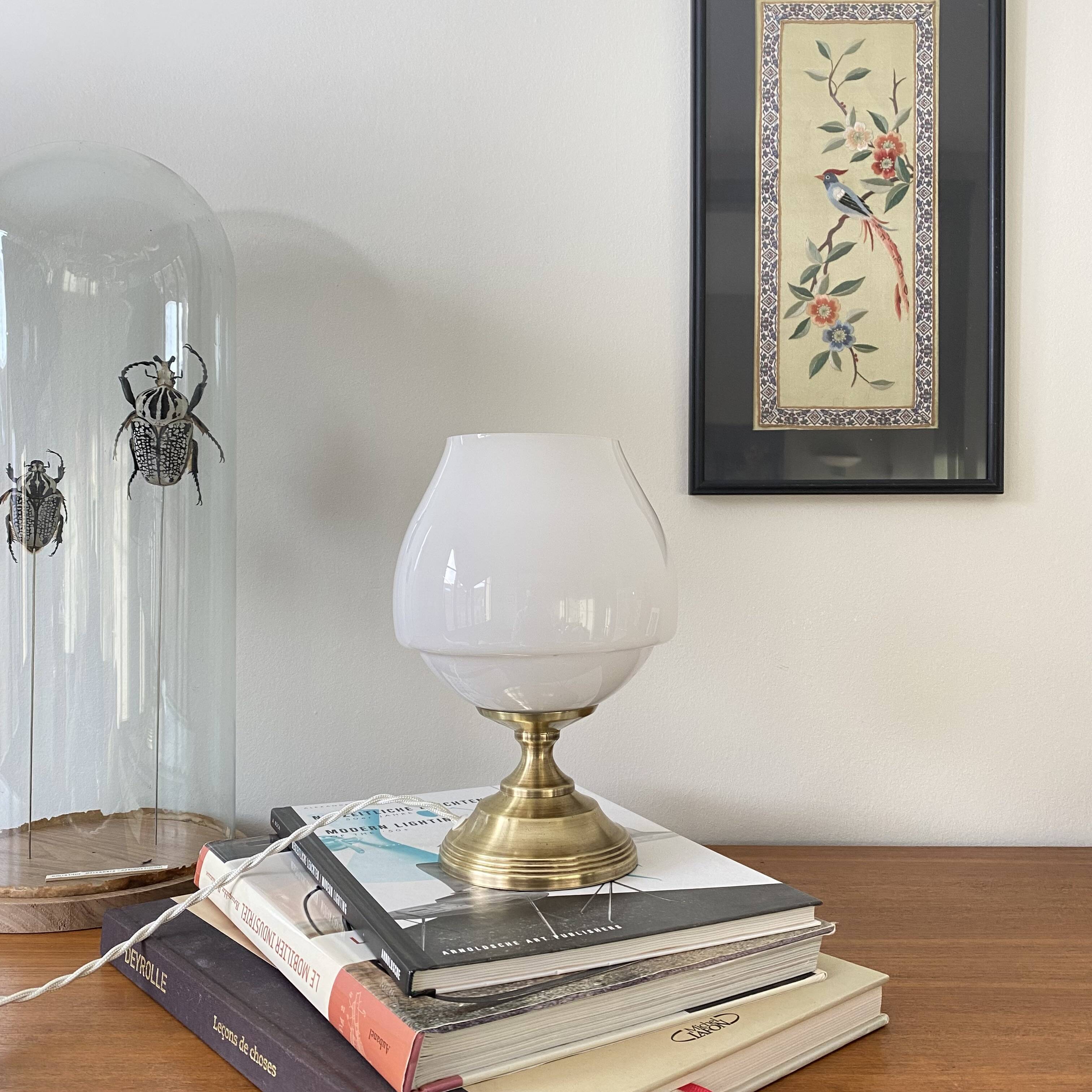 Antique white opaline glass globe table lamp with a brass base.
