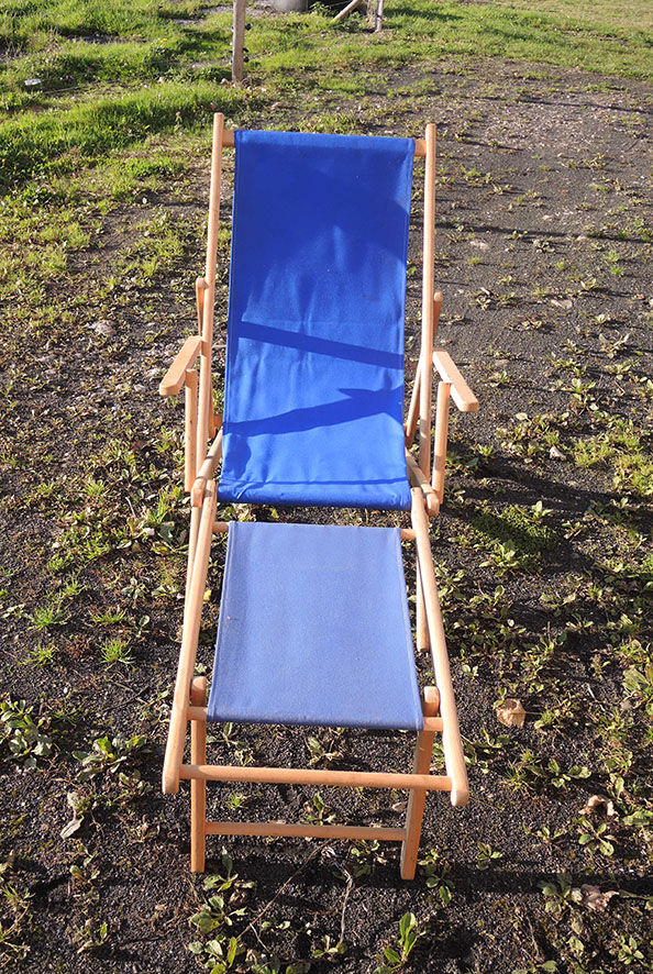 Old sunbathing in wooden & blue fabric