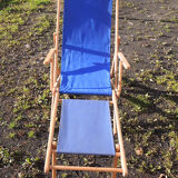 Old sunbathing in wooden & blue fabric
