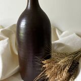 Old bottle in matte brown stoneware