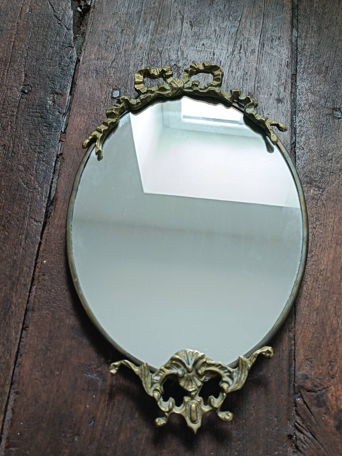 Antique mirror, oval with brass crest