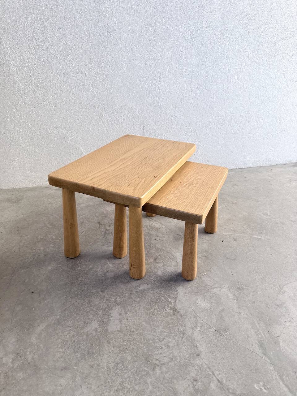 Two stools or small nesting tables in light oak.