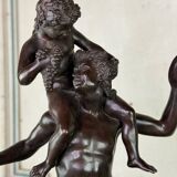 Dionysus on the shoulders of a satyr, bronze after the antique on a yellow Siena base.