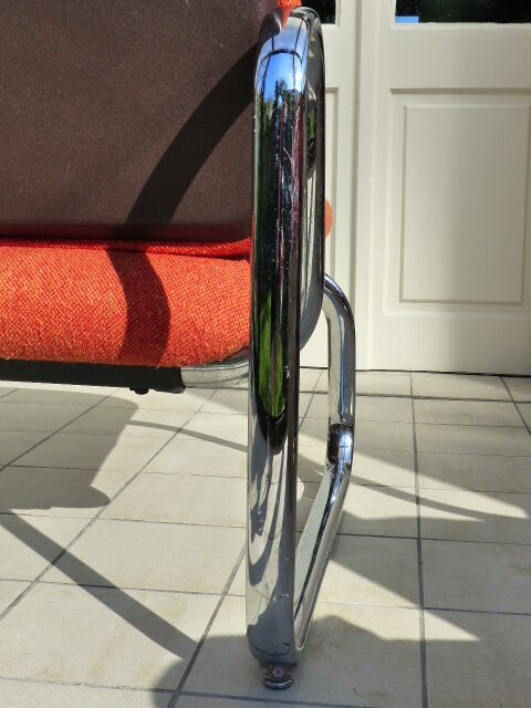 The 1970s orange armchair fabric and chrome metal