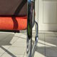 The 1970s orange armchair fabric and chrome metal
