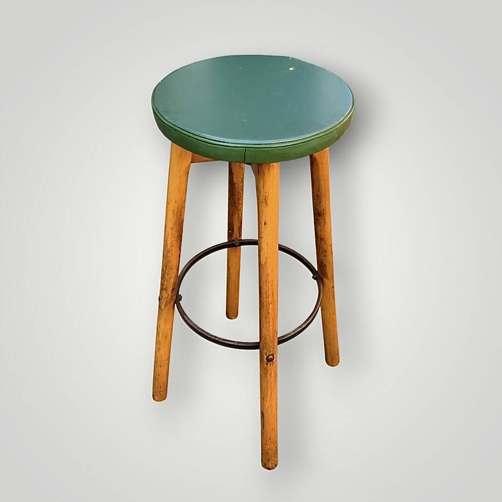 Old solid wood bar stool, metal footrest, green leatherette seat
