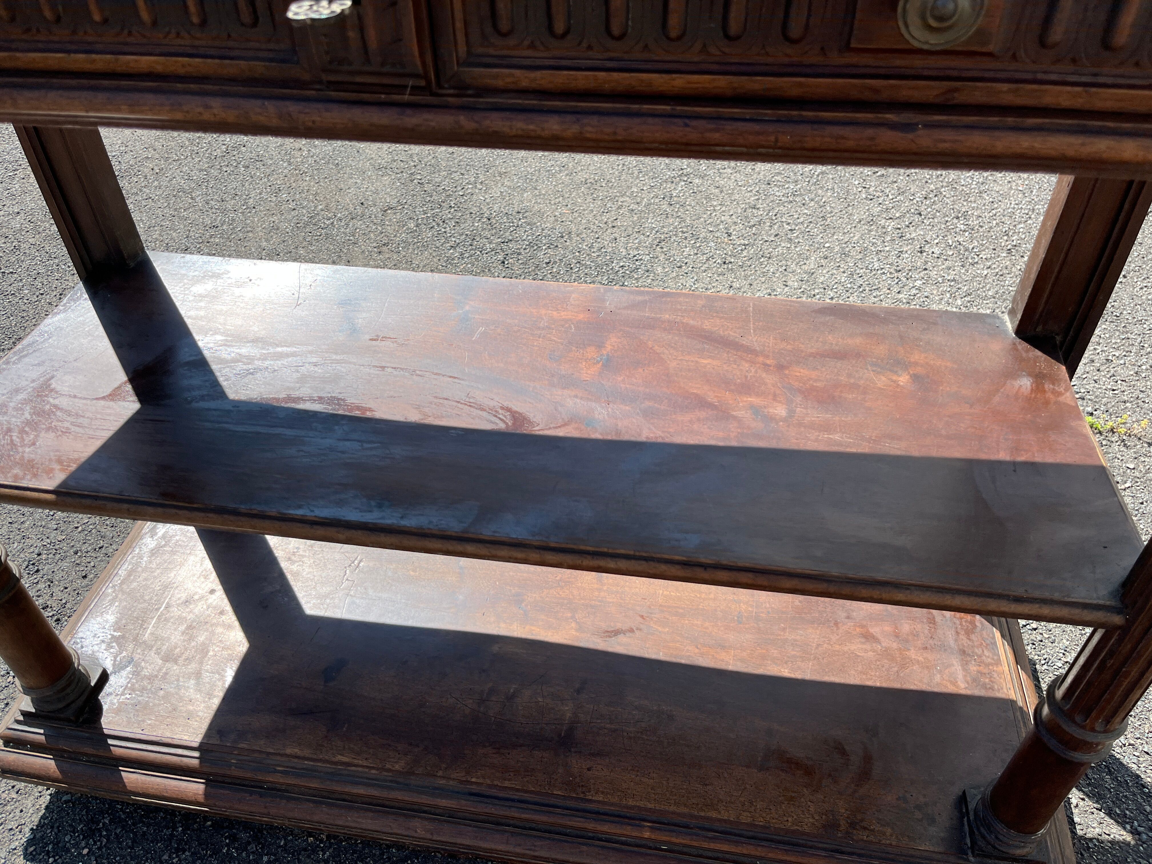 Carved wooden console table with three shelves and drop-leaf flap