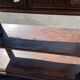 Carved wooden console table with three shelves and drop-leaf flap