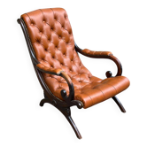 Chesterfield armchair in leather and carved solid wood