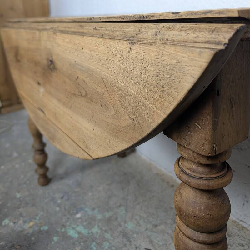 Antique wooden drop-leaf table with turned legs.