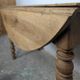 Antique wooden drop-leaf table with turned legs.