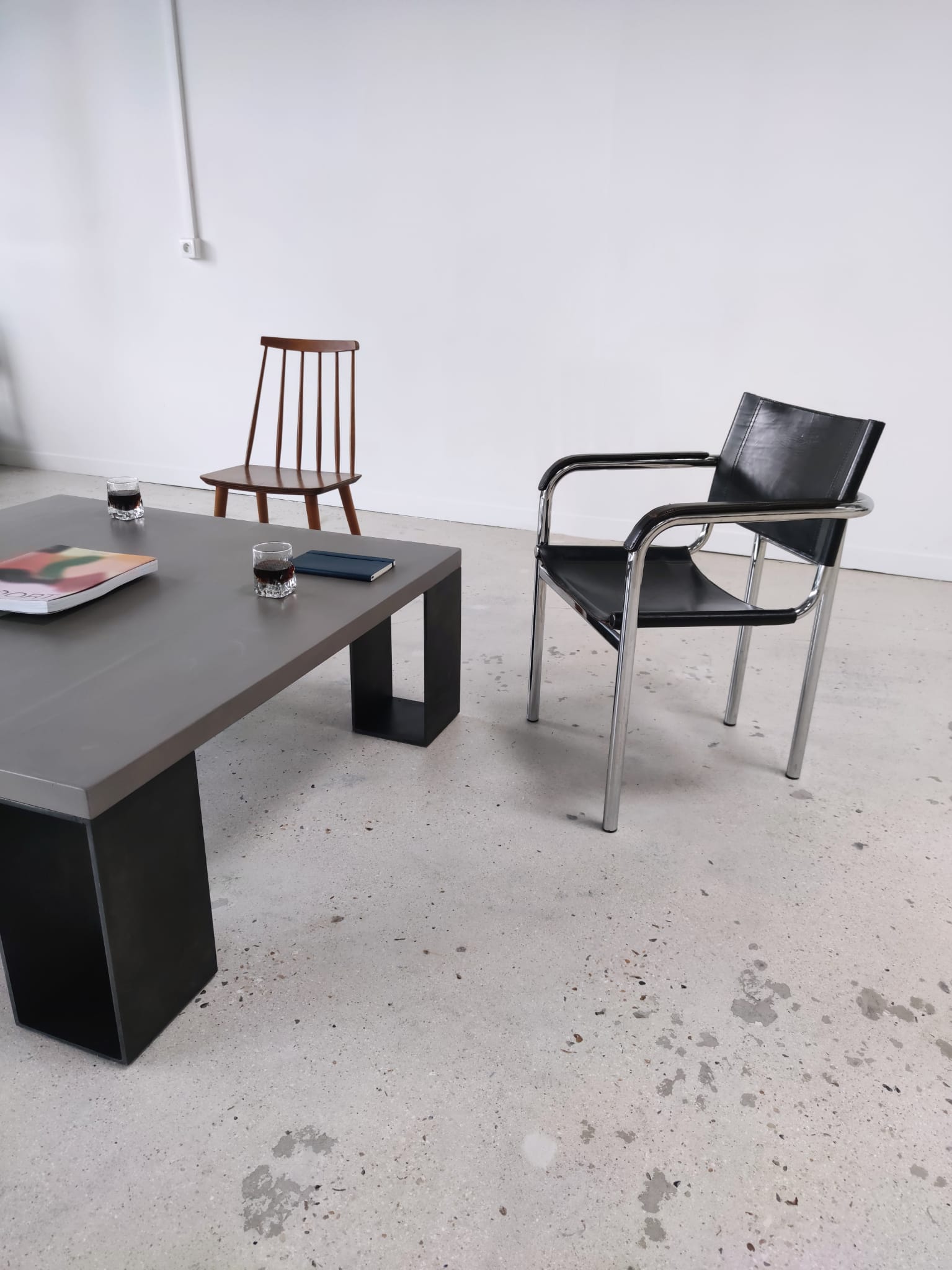 Table basse minimaliste en béton ciré et acier massif 1m20x1m20