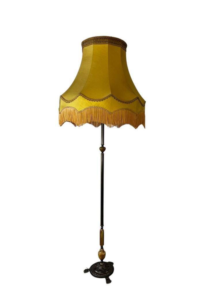 Vintage gold floor lamp with fringed shade.