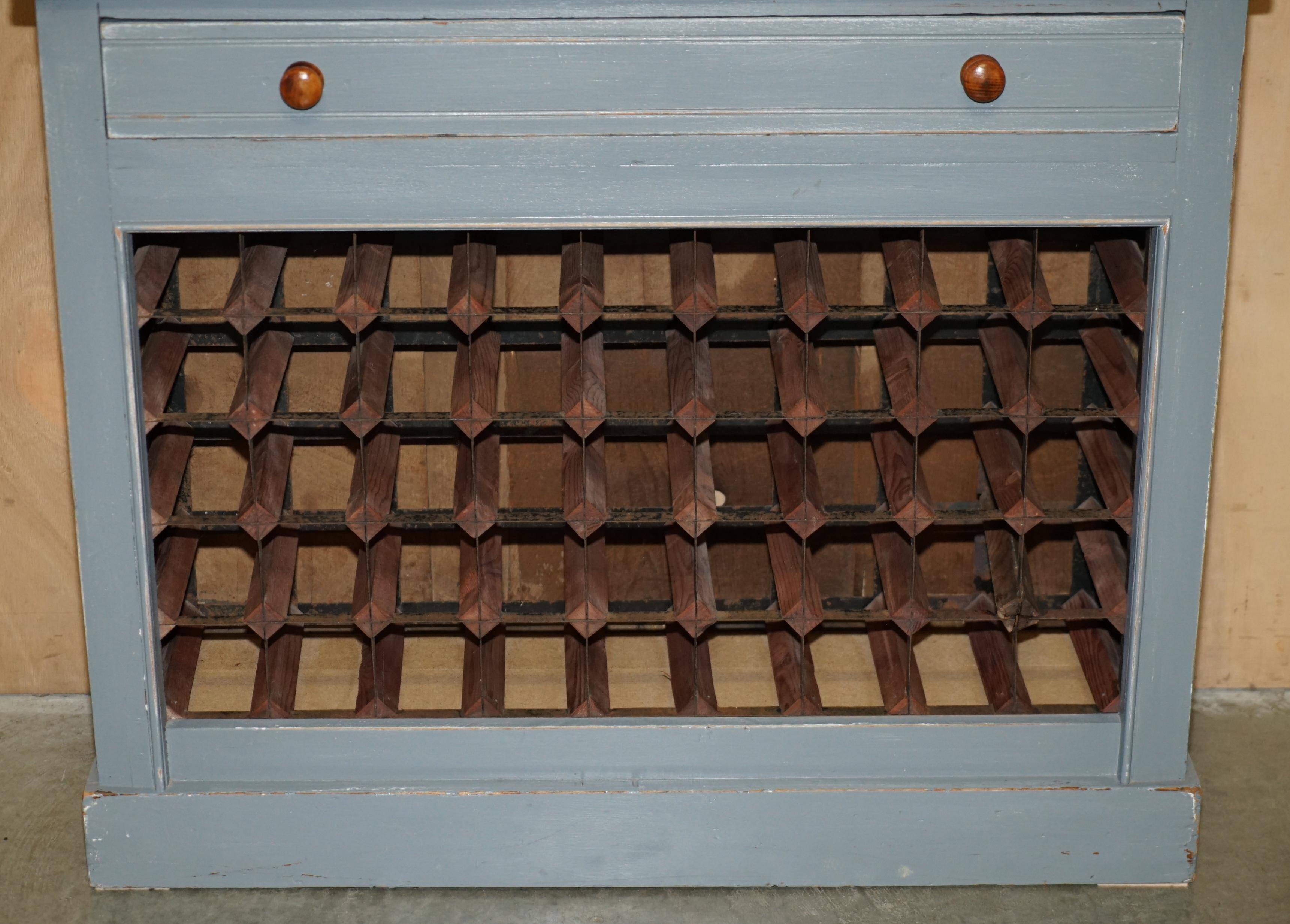 Vintage wooden furniture for 45 wine bottles with a drawer.