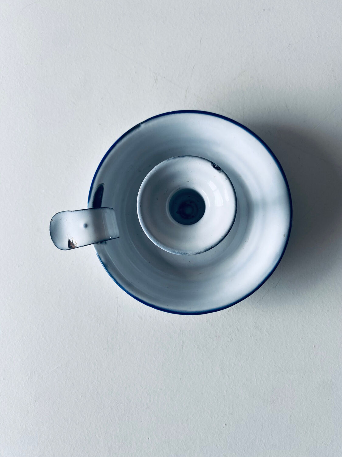 Old candle holder in white enameled metal