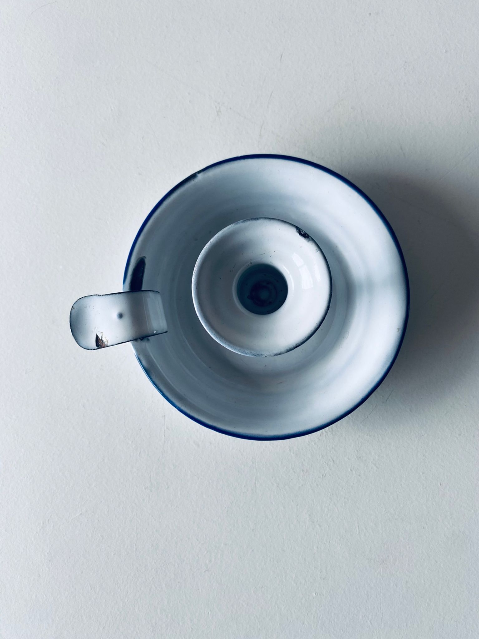 Old candle holder in white enameled metal