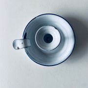 Old candle holder in white enameled metal