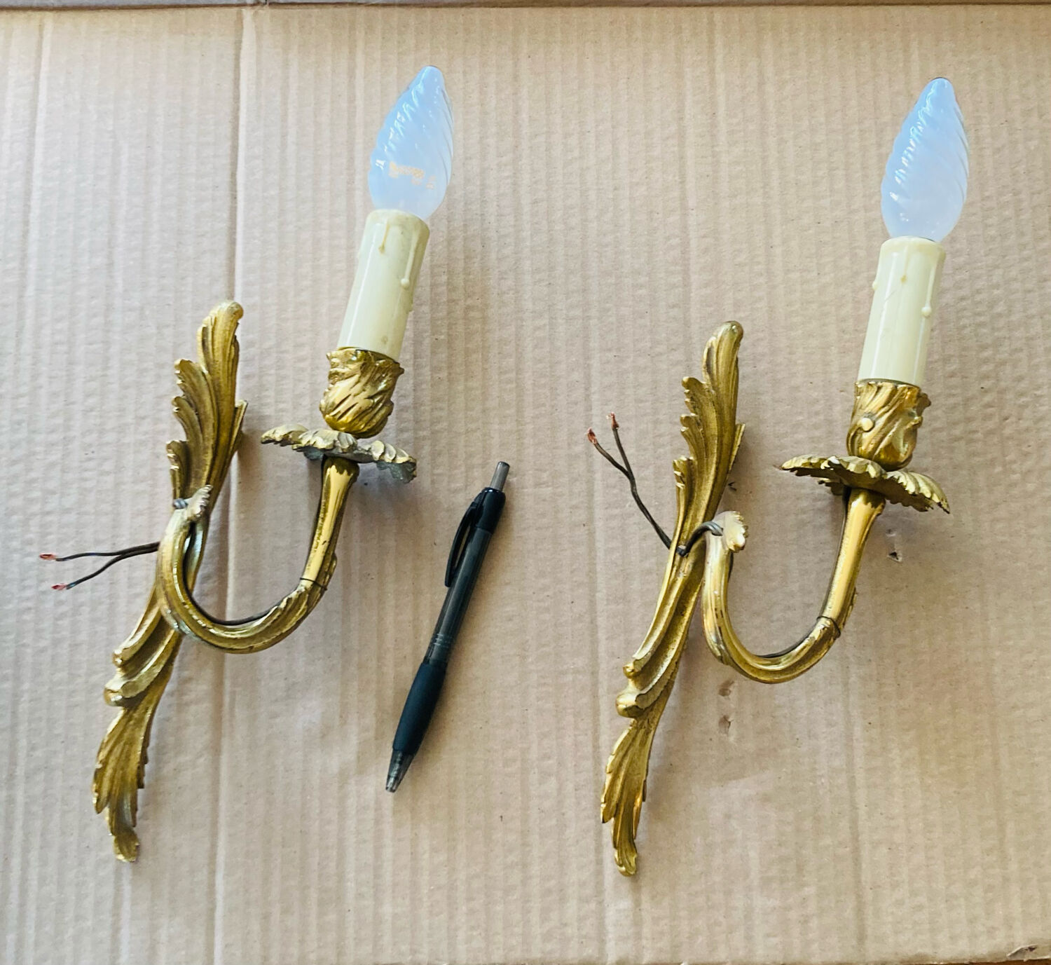 Bronze wall lights in the Louis XV style with curved branches and leaf decorations.