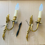 Bronze wall lights in the Louis XV style with curved branches and leaf decorations.