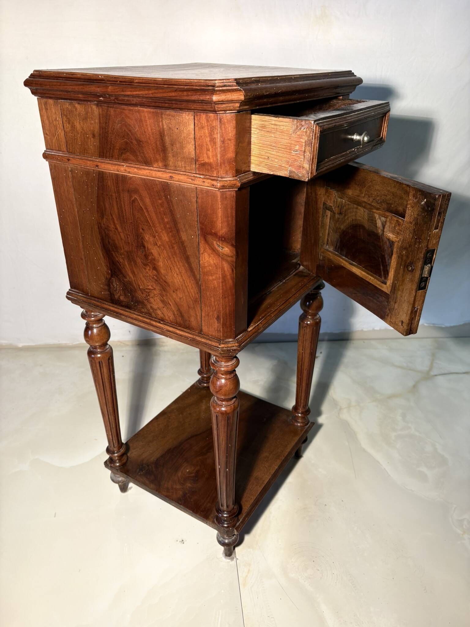 Antique wooden bedside table with turned legs.