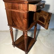 Antique wooden bedside table with turned legs.
