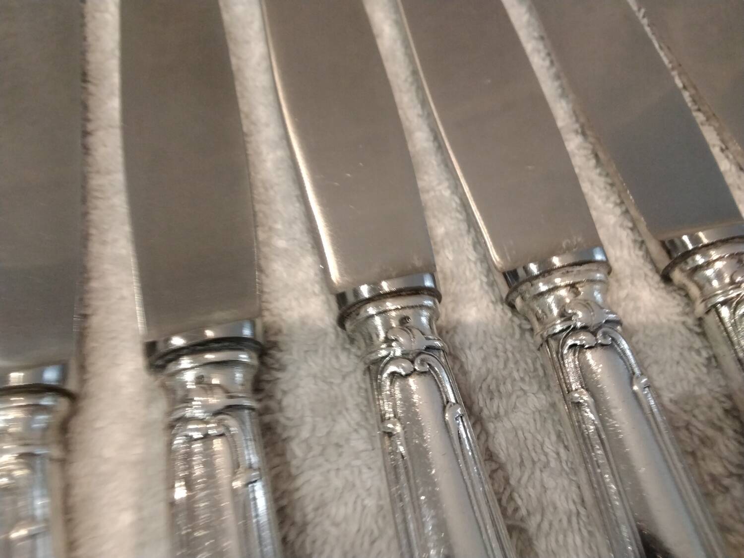 12 silver-plated metal table knives with rocaille ribbon decoration, 25.1 cm