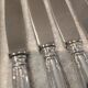 12 silver-plated metal table knives with rocaille ribbon decoration, 25.1 cm