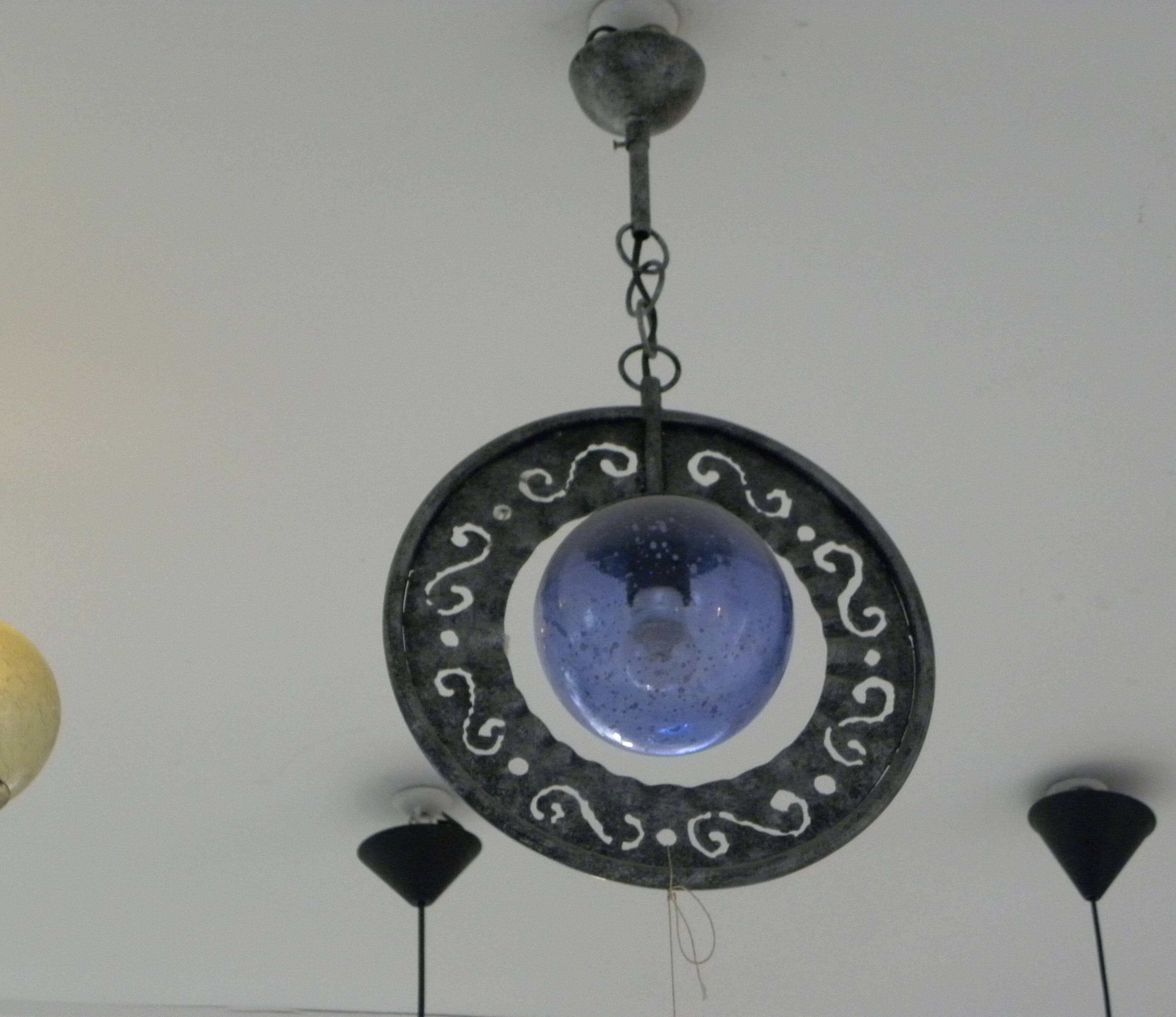 Patinated metal chandelier with cobalt blue blown glass in a rustic style.