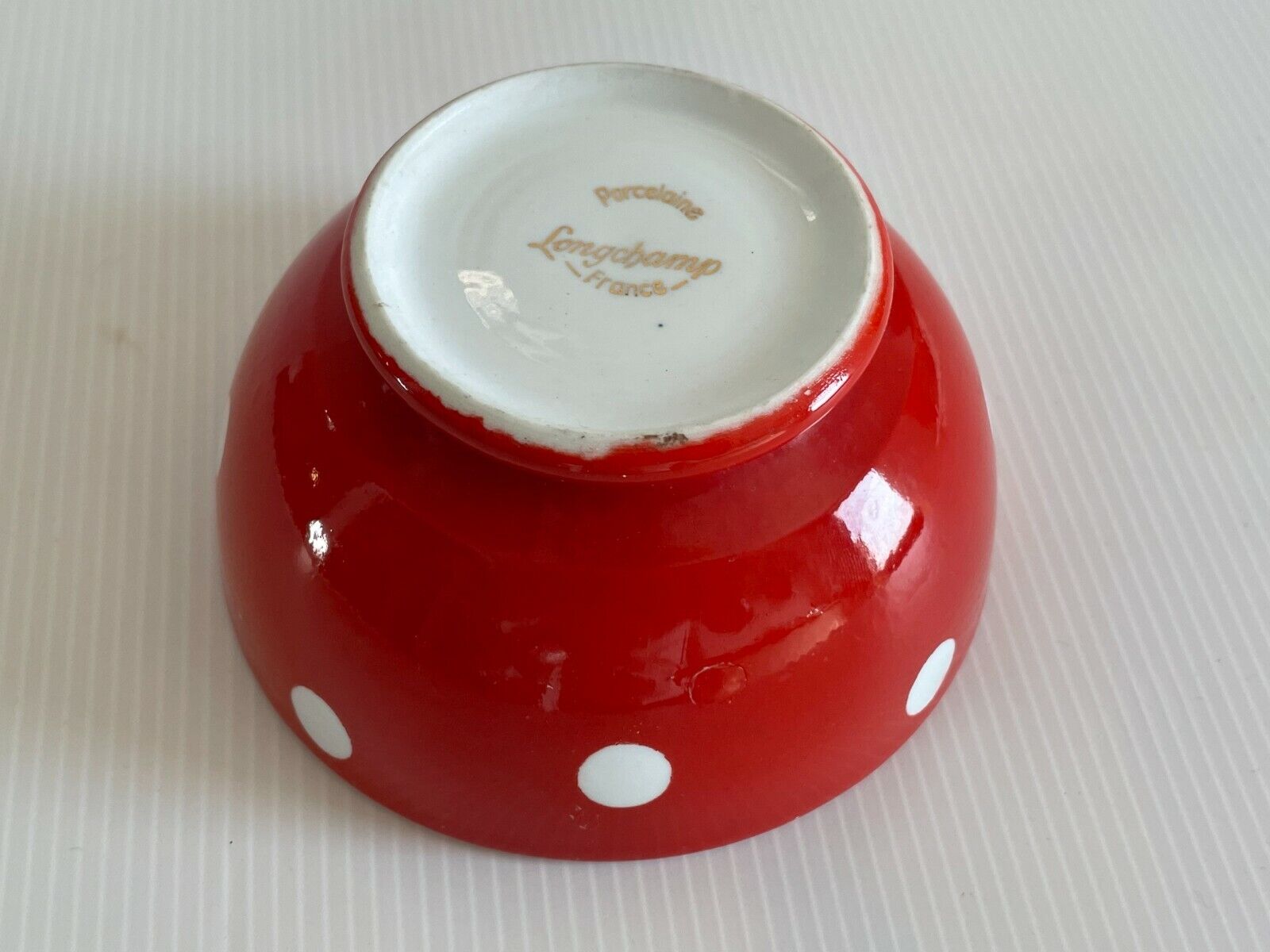 Red bowl with white polka dots signed Longchamp Porcelaine France
