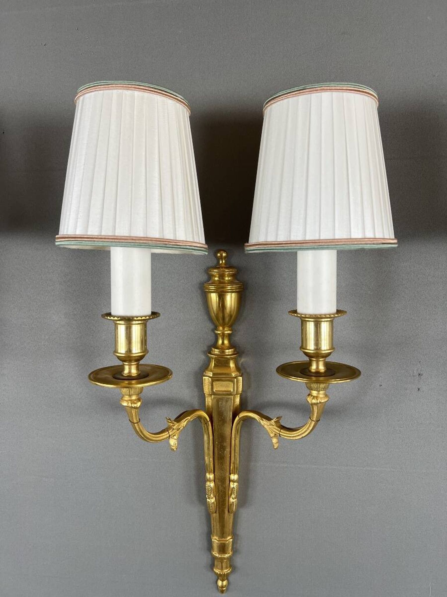 Set of three Louis XVI style wall sconces in gilded bronze, 20th century.