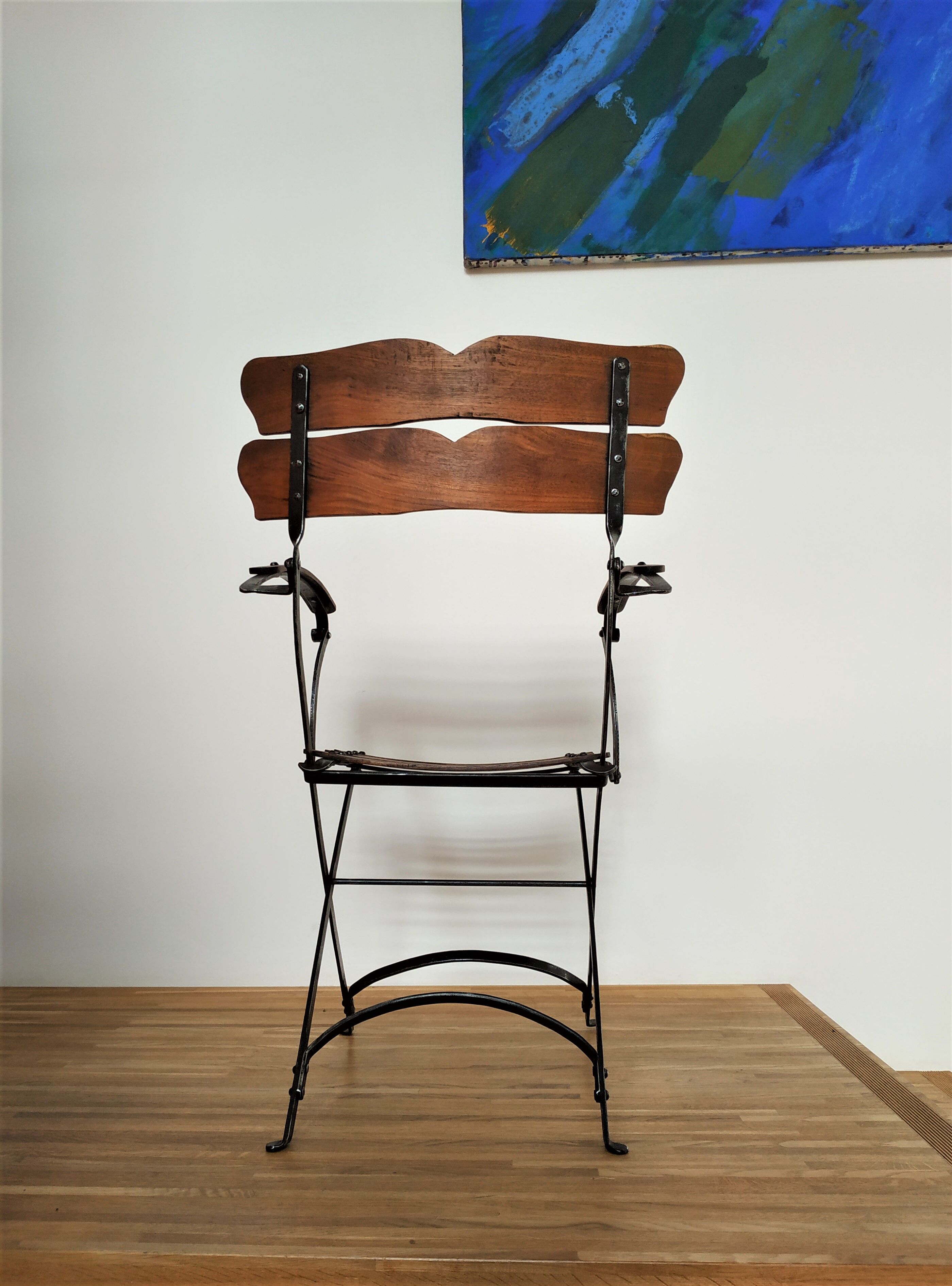 Folding garden chair with teak slats on a wrought iron structure