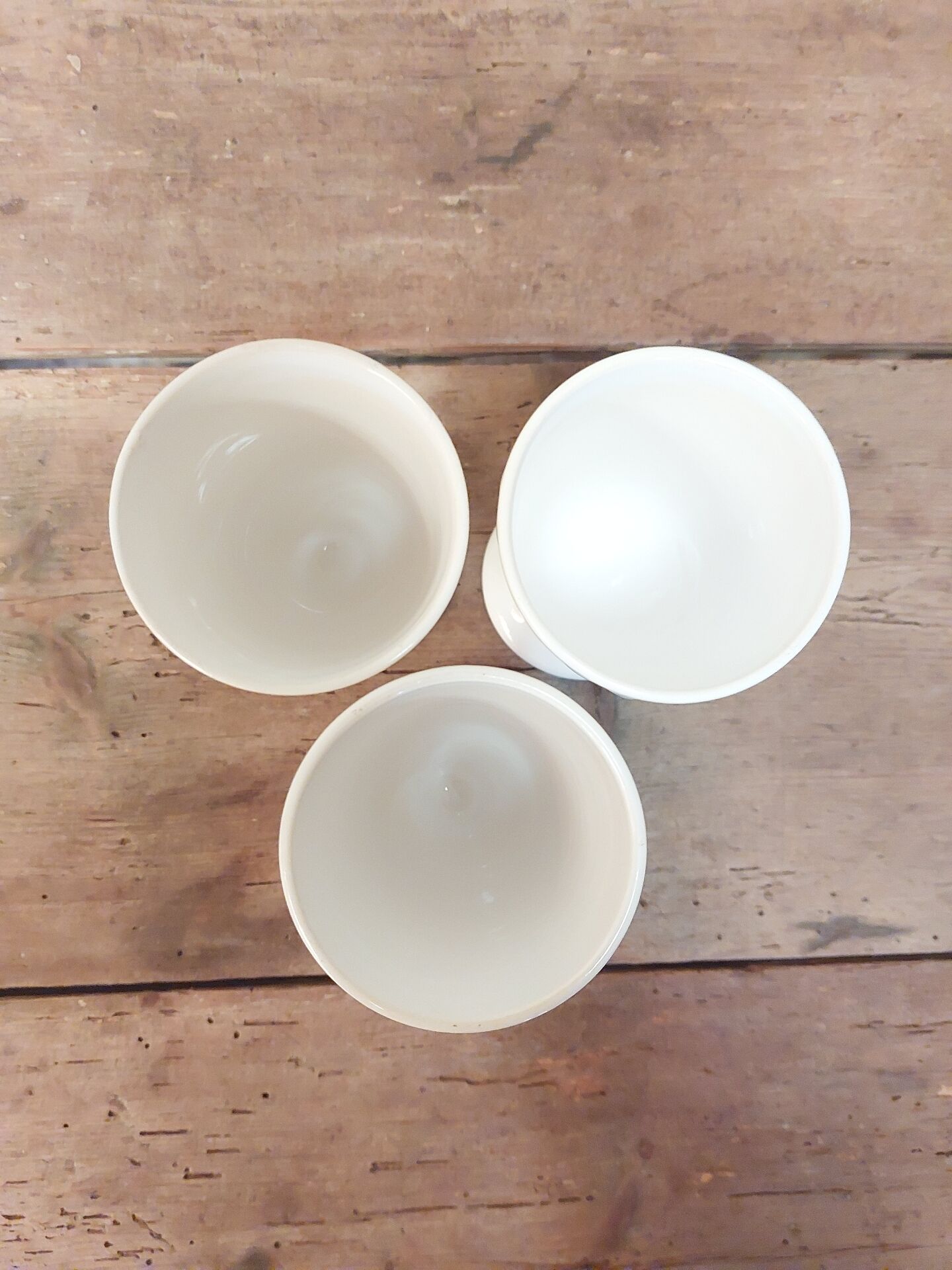 Three antique cups decorated with fleur-de-lis.