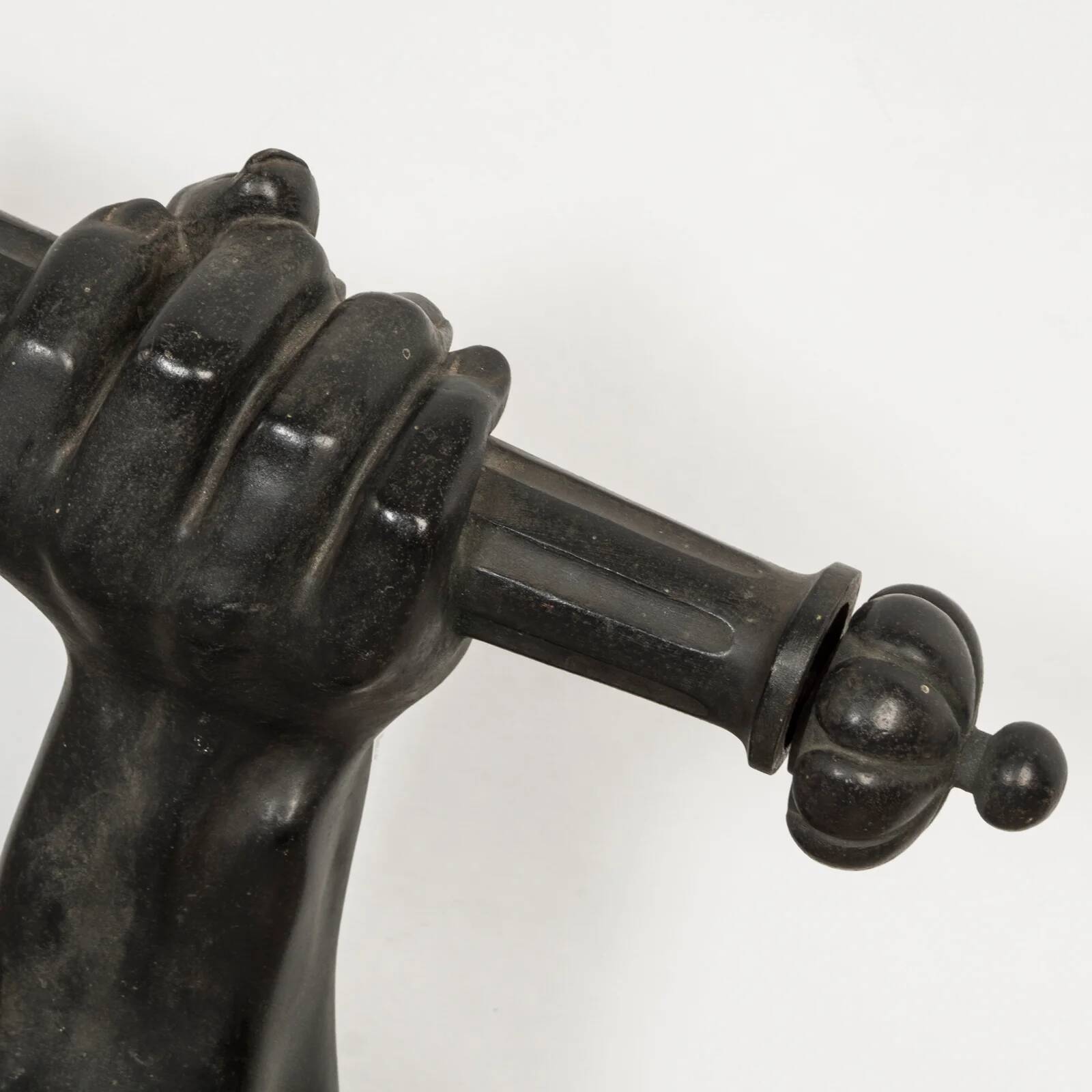 Wall lamp in iron shaped like an arm.