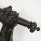 Wall lamp in iron shaped like an arm.