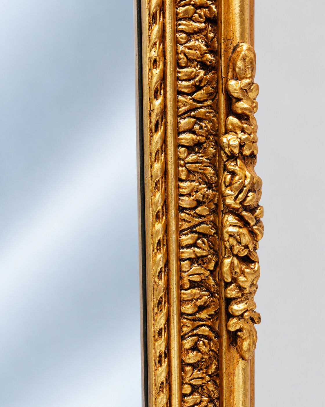 Grand miroir baroque en or avec un crête orné.